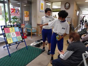 生徒さんが利用者様に遊び方を教える様子