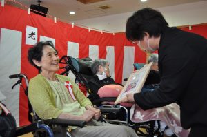 園長からご利用者に祝い状を贈呈する様子