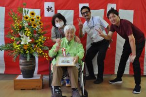 祝い状を持ち笑顔のご利用者